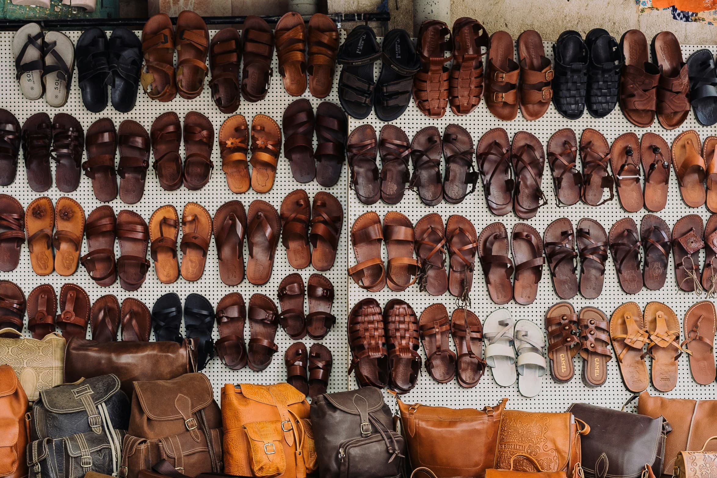 Rows of handmade sandals laid out on white cloth